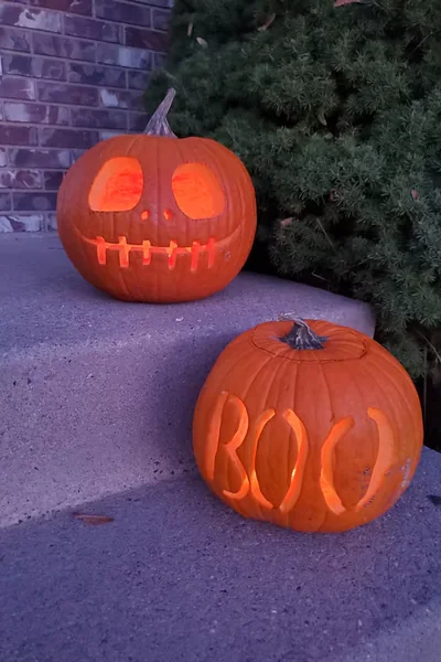 two carved jack-o’-lanterns on the front steps