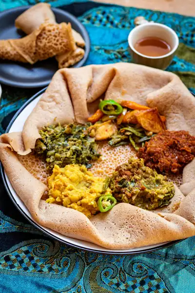Ethiopian meal served on injera with vegetables and tea