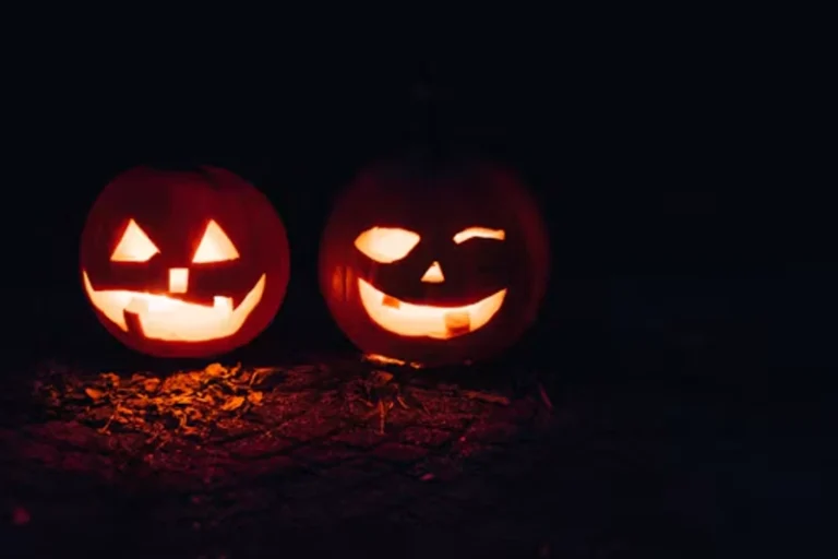 Glowing carved pumpkins displayed outdoors at night