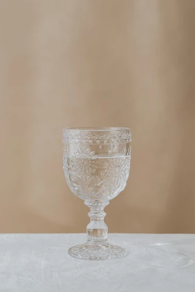 Clear vintage-style glass goblet with embossed floral details