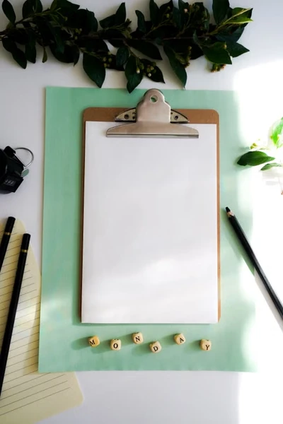 Blank notepad on a desk with cubes that say Monday getting ready for the next day
