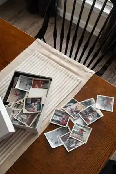 dining room table with an open box of vintage family photos