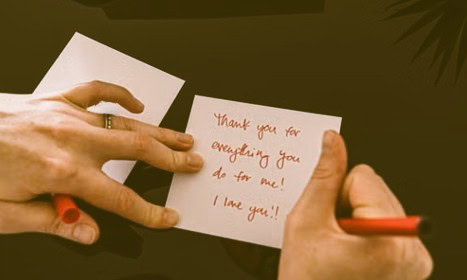 Person writing a handwritten note of appreciation