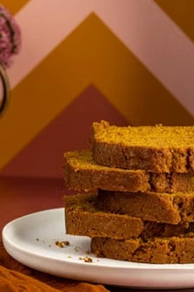 Slices of pumpkin bread stacked on a white plate