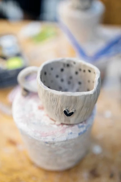 handmade small white mug with hand painted heart on the outside and polka dots on the inside