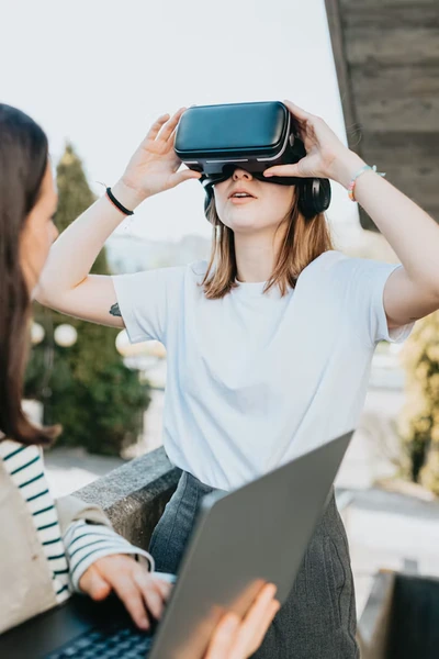Young woman using a virtual reality headset outdoors